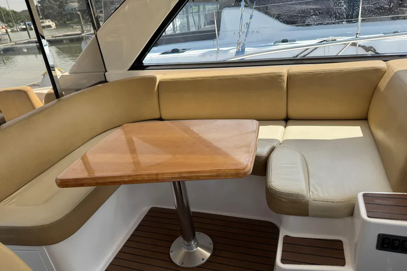 Slide: The Image of Interior of 2010 Regal 44 Sport Coupe with beige seating and wooden table. - 7