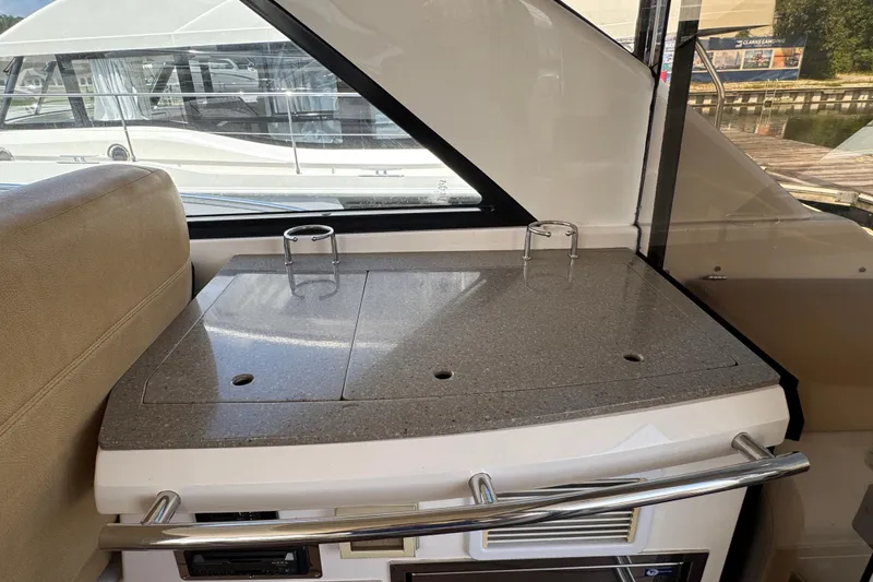 Slide: The Image of Interior of 2010 Regal 44 Sport Coupe yacht with sleek countertop and cup holders. - 8