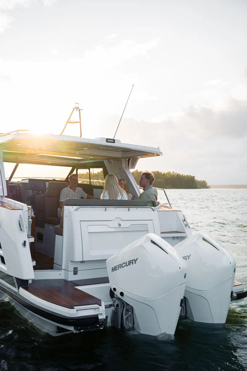 Slide: The Image of 2025 Aquador 300 HT boat cruising with passengers at sunset. - 10