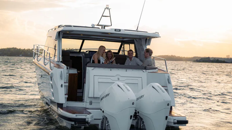 Slide: The Image of 2025 Aquador 300 HT boat cruising with passengers at sunset. - 13