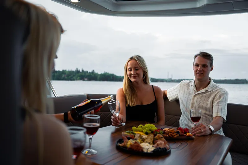 Slide: The Image of People enjoying wine and snacks on a 2025 Aquador 300 HT boat. - 17