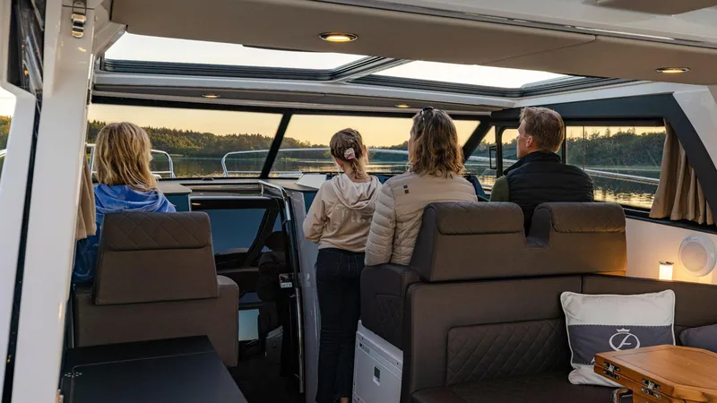 Slide: The Image of Four people enjoying a sunset view from inside a 2025 Aquador 300 HT boat. - 22