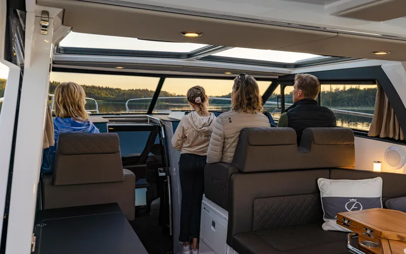 Slide: The Image of People enjoying a scenic view from inside a 2025 Aquador 300 HT boat. - 23