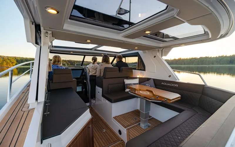 Slide: The Image of Interior of 2025 Aquador 300 HT boat with modern seating and scenic lake view. - 24