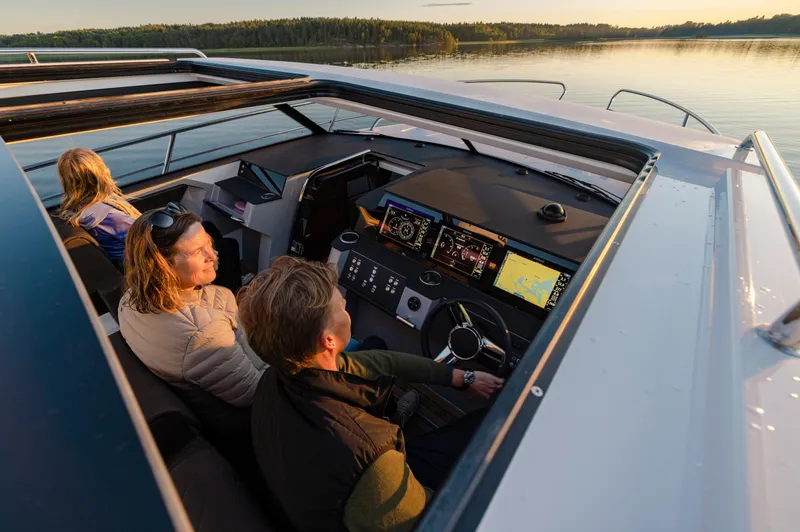 Slide: The Image of 2025 Aquador 300 HT boat interior with passengers enjoying a serene sunset cruise. - 3