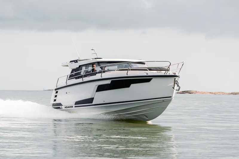 Slide: The Image of 2025 Aquador 300 HT cruising on calm waters under a cloudy sky. - 5