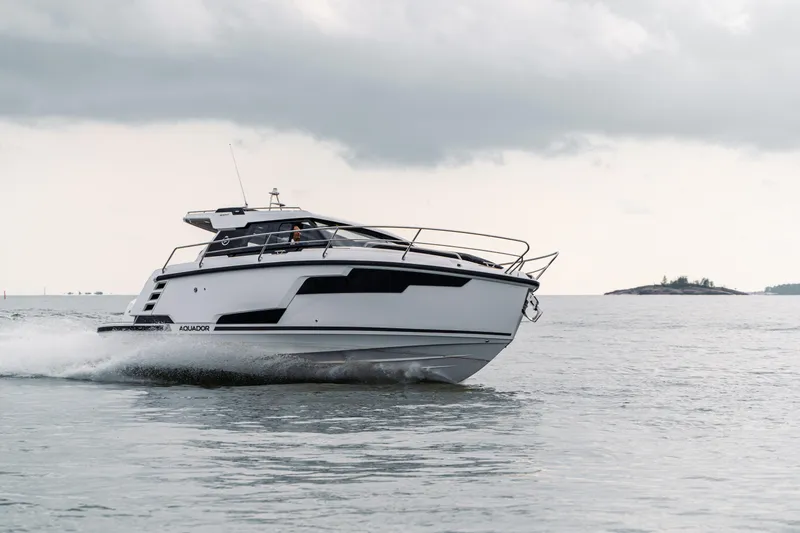 Slide: The Image of 2025 Aquador 300 HT cruising on open water under cloudy skies. - 7