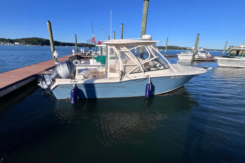 Slide: The Image of 2015 Grady White 255 Freedom boat docked in a marina under clear blue skies. - 3