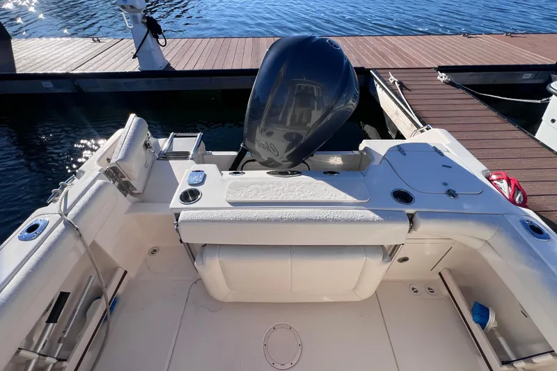 Slide: The Image of 2015 Grady White 255 Freedom boat docked, showcasing spacious deck and motor. - 6