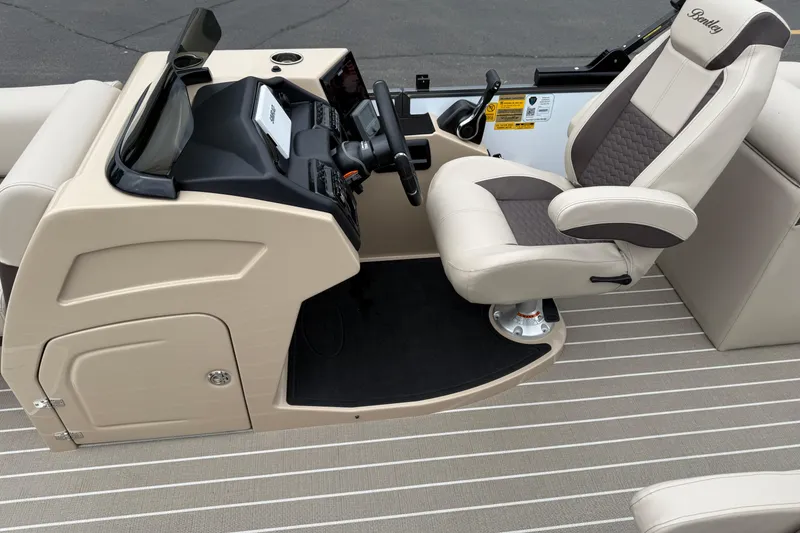 Slide: The Image of 2026 Bentley Pontoons Elite 253 Admiral helm with luxurious captain's chair and modern dashboard. - 20