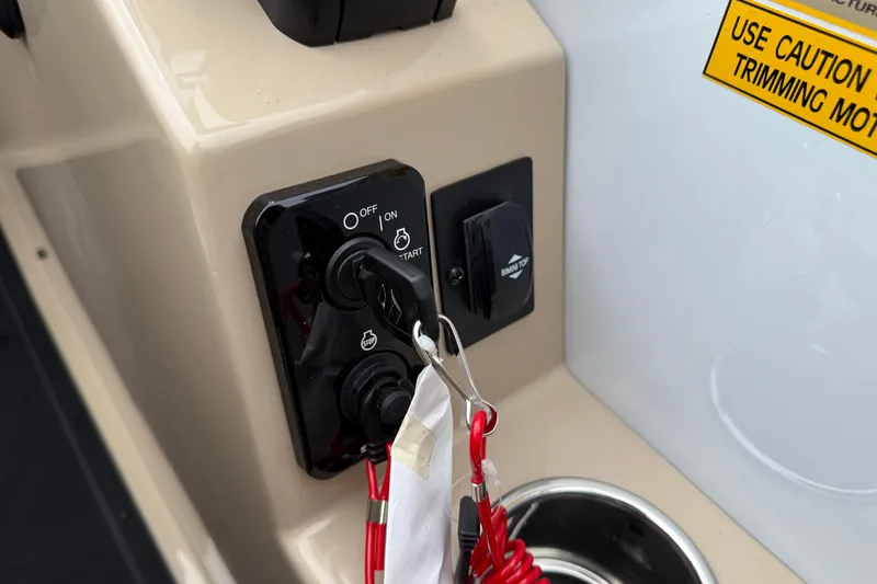 Slide: The Image of Control panel of 2026 Bentley Pontoons Elite 253 Admiral with ignition switch and caution label. - 23