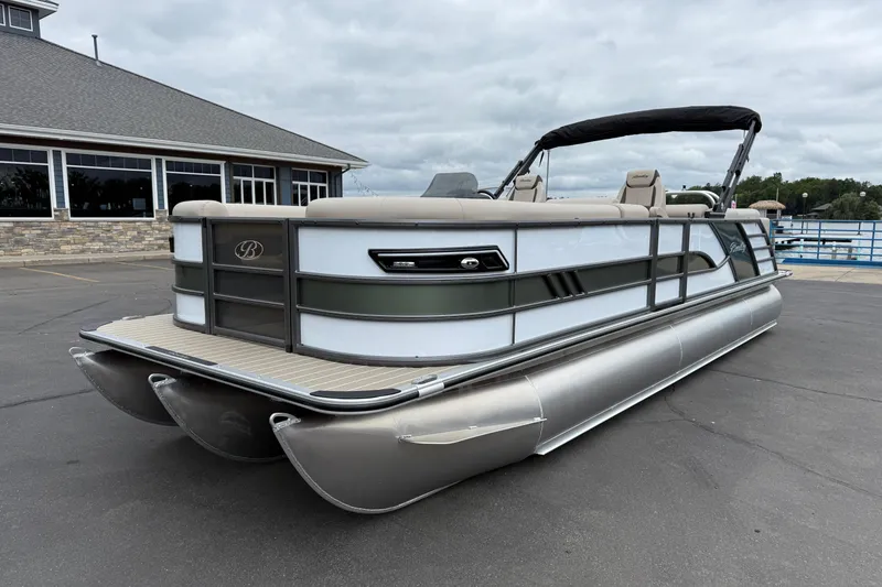 Slide: The Image of 2026 Bentley Pontoons Elite 253 Admiral, docked near a building under cloudy skies. - 3