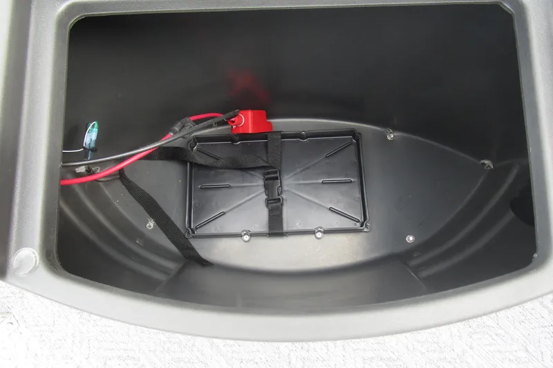 Slide: The Image of Battery compartment of 2026 Sun Tracker Bass Buggy 18 DLX with wiring and secure strap. - 16