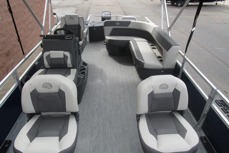 Slide: The Image of 2026 Sun Tracker Bass Buggy 18 DLX pontoon boat interior with gray seating and steering console. - 17