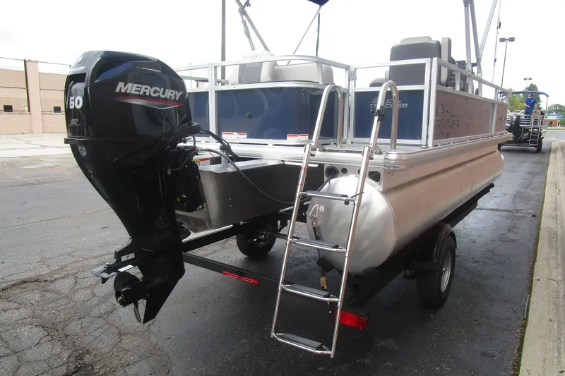 Slide: The Image of 2026 Sun Tracker Bass Buggy 18 DLX pontoon boat with Mercury 60 engine, parked on trailer. - 6