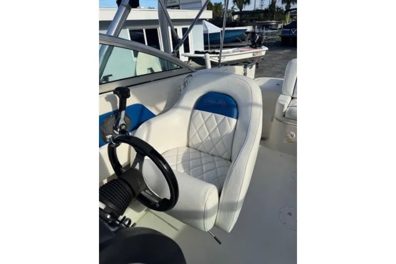 Slide: The Image of 2009 Sea Ray 230 Sundeck boat interior with white and blue captain's seat. - 14