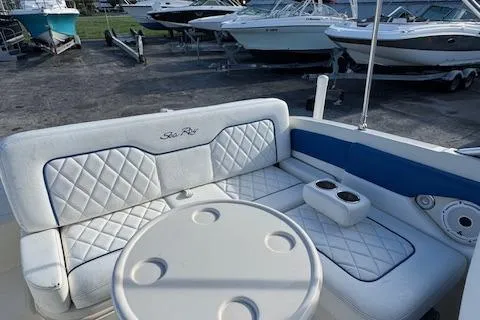 Slide: The Image of 2009 Sea Ray 230 Sundeck interior with cushioned seating and round table. - 16