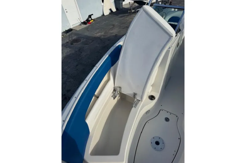 Slide: The Image of 2009 Sea Ray 230 Sundeck boat with open storage compartment and blue seating. - 20