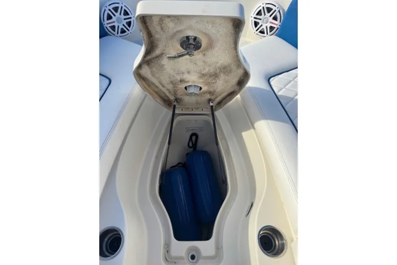 Slide: The Image of Open storage compartment on 2009 Sea Ray 230 Sundeck boat with blue fenders inside. - 24