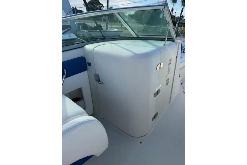 Slide: The Image of 2009 Sea Ray 230 Sundeck interior with white seating and windshield. - 25