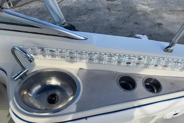 Slide: The Image of 2009 Sea Ray 230 Sundeck boat sink and counter with fish identification chart. - 30