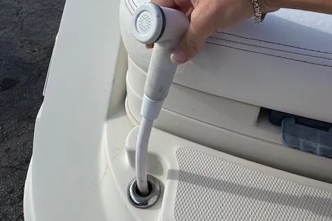 Slide: The Image of Hand holding a shower nozzle on a 2009 Sea Ray 230 Sundeck boat. - 32