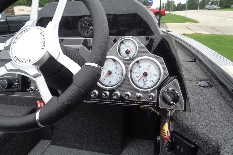 Slide: The Image of 2026 Lund 2075 Pro-V Bass XS boat interior with steering wheel and dashboard controls. - 12