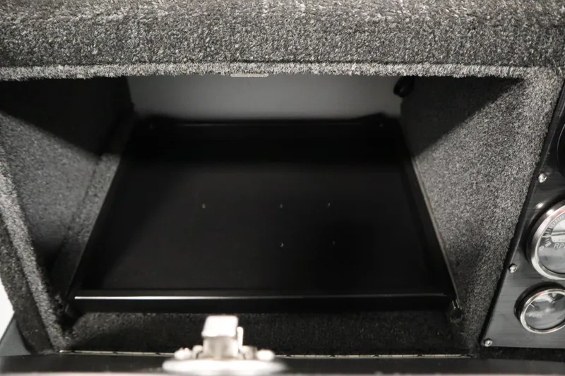 Slide: The Image of Carpeted storage compartment in 2017 Lowe 1610 FM boat, with adjacent gauges. - 26