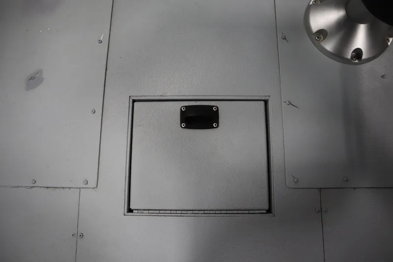 Slide: The Image of 2017 Lowe 1610 FM boat floor with storage compartment and metal fixture. - 29