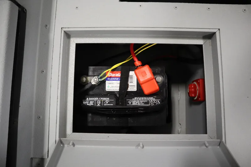 Slide: The Image of Battery compartment of 2017 Lowe 1610 FM boat with visible wiring and safety labels. - 35