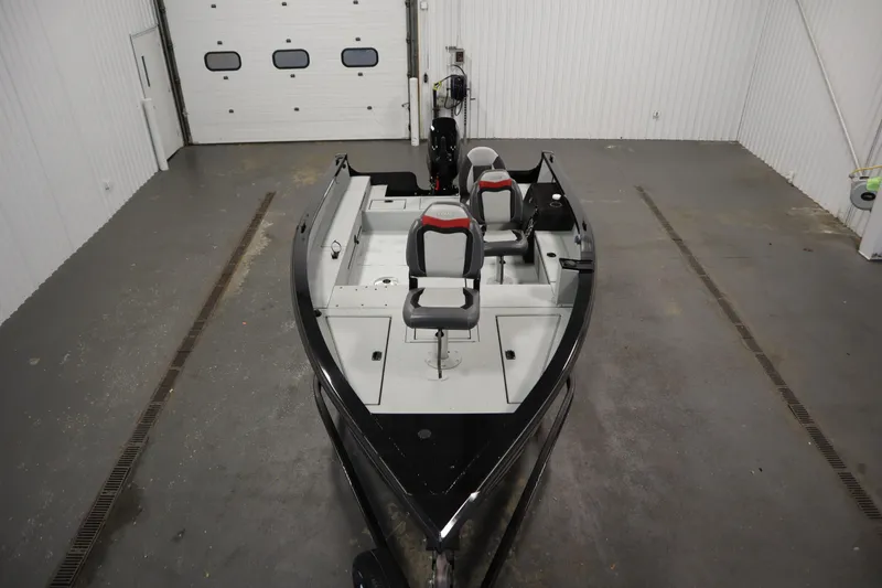 Slide: The Image of 2017 Lowe 1610 FM boat in a garage, featuring dual seats and a sleek design. - 8