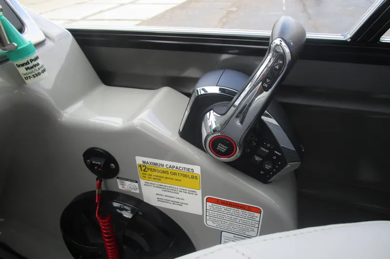 Slide: The Image of 2024 Regency 230 LE3 boat control panel with throttle and capacity warning labels. - 11