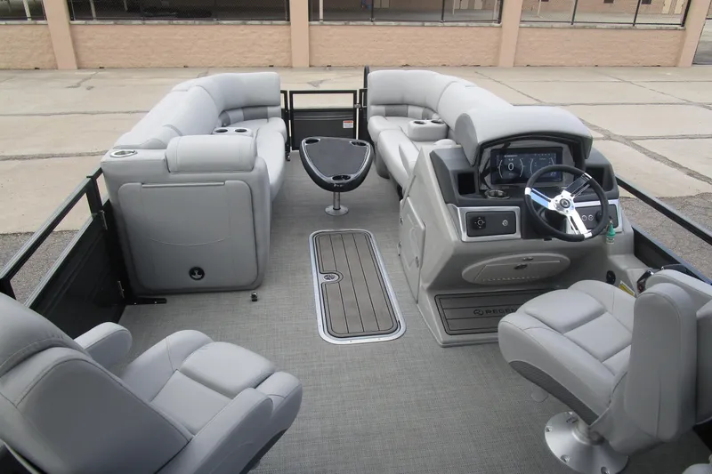 Slide: The Image of 2024 Regency 230 LE3 pontoon boat interior with plush seating and modern dashboard. - 12