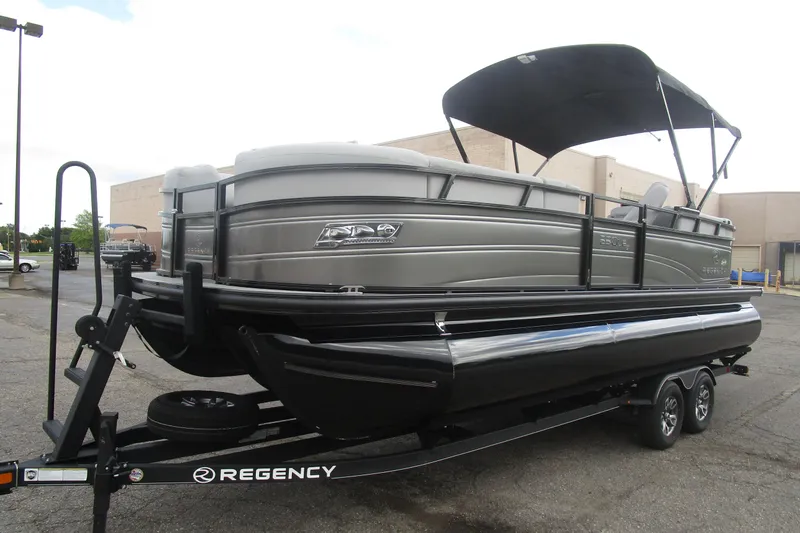 Slide: The Image of 2024 Regency 230 LE3 pontoon boat on trailer, parked outdoors. - 5