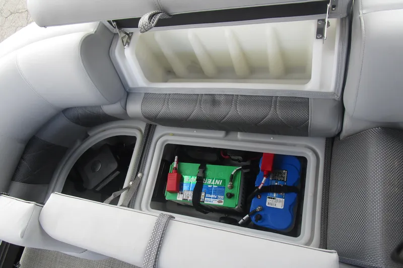Slide: The Image of 2024 Regency 230 LE3 boat storage compartment with battery setup. - 9