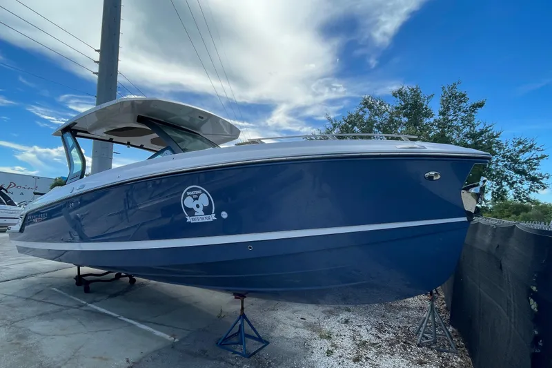 Slide: The Image of 2026 Monterey 30 ELITE boat with sleek blue design, displayed outdoors. - 1