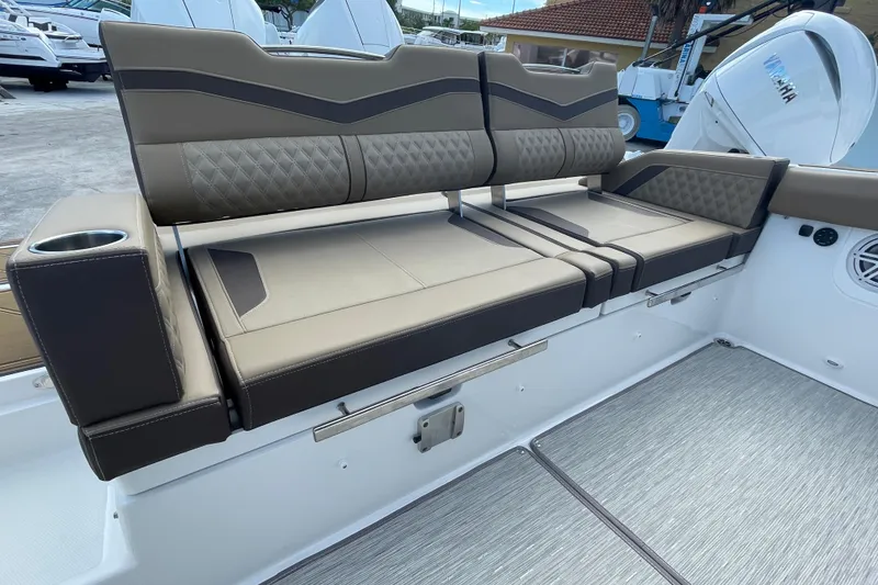 Slide: The Image of 2026 Monterey 30 ELITE boat seating with cup holder, featuring luxurious brown upholstery. - 17