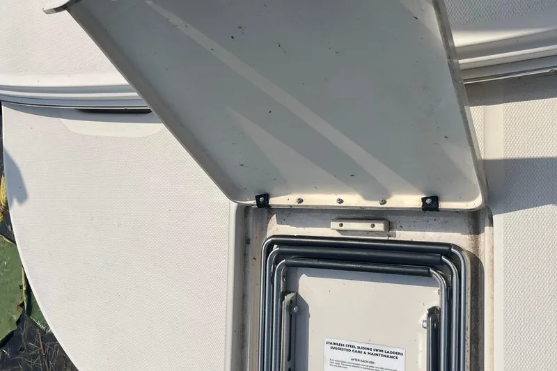 Slide: The Image of Open hatch on 2001 Sea Ray 240 Sundancer boat, revealing stainless steel swim ladder. - 12