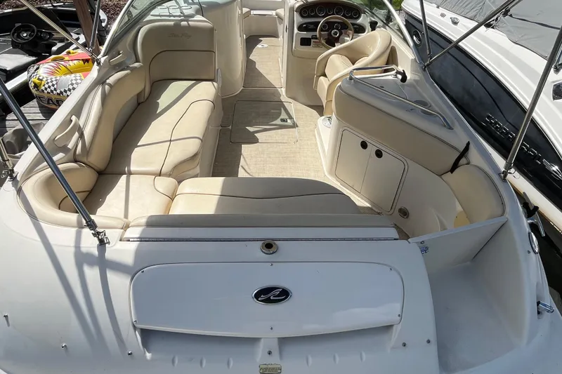 Slide: The Image of 2001 Sea Ray 240 Sundancer boat interior with beige seating and steering console. - 16