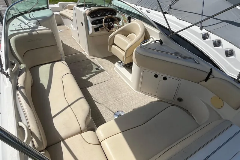 Slide: The Image of 2001 Sea Ray 240 Sundancer boat interior with beige seating and steering console. - 17