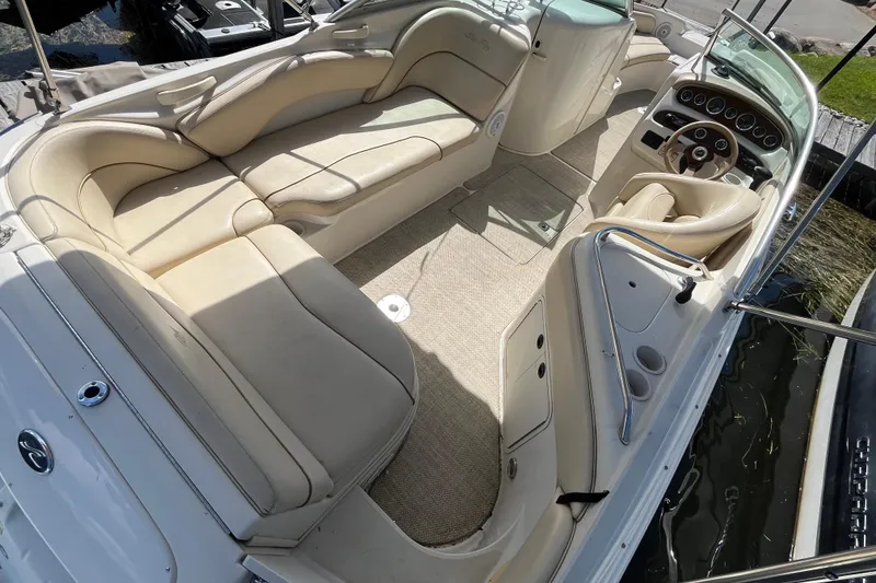 Slide: The Image of 2001 Sea Ray 240 Sundancer boat interior with beige seating and steering console. - 18