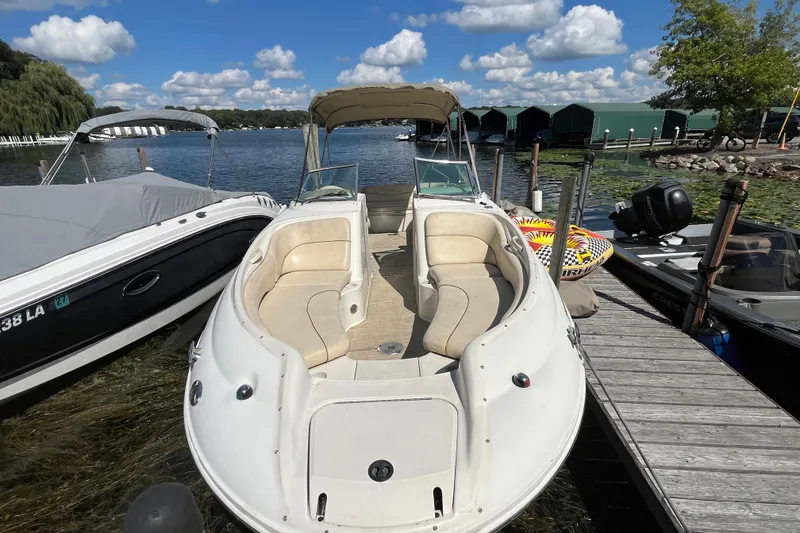 Slide: The Image of 2001 Sea Ray 240 Sundancer docked by a scenic lake under a blue sky. - 31
