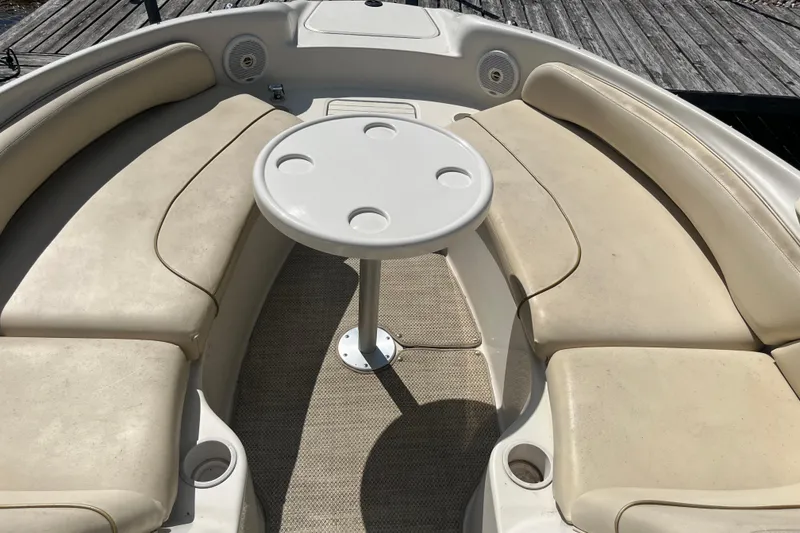 Slide: The Image of 2001 Sea Ray 240 Sundancer boat interior with cushioned seating and round table. - 4
