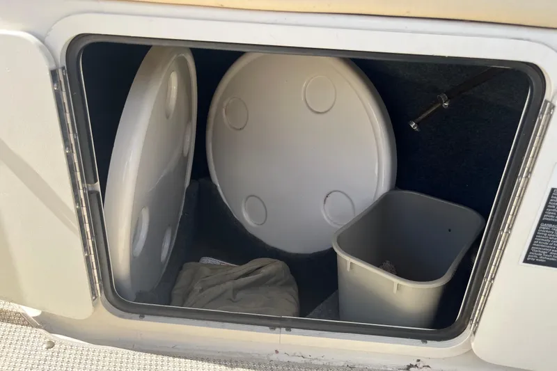 Slide: The Image of Storage compartment of 2001 Sea Ray 240 Sundancer with lids and a bin. - 6