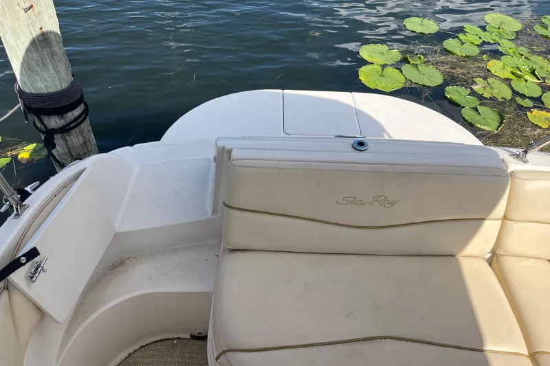 Slide: The Image of 2001 Sea Ray 240 Sundancer boat interior with seating, docked near water lilies. - 9