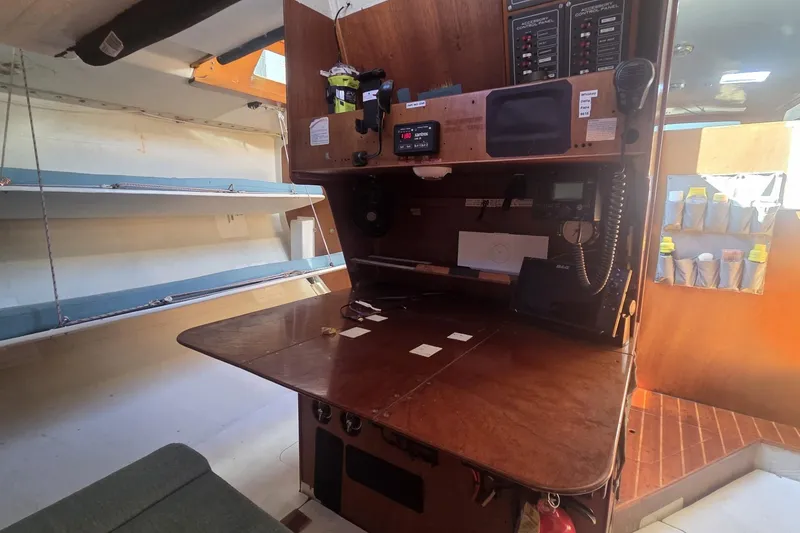Slide: The Image of Navigation station inside 1986 Santa Cruz 70 sailboat with control panels and equipment. - 10
