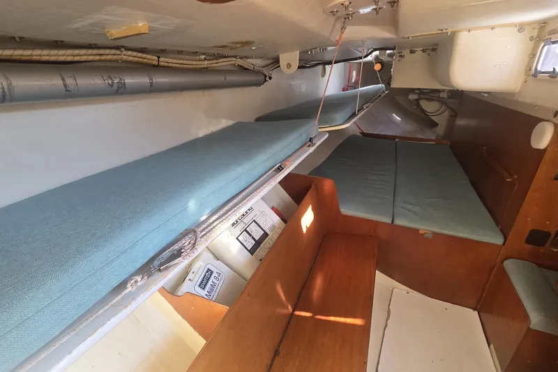 Slide: The Image of Interior of 1986 Santa Cruz 70 sailboat with blue cushions and wooden accents. - 15