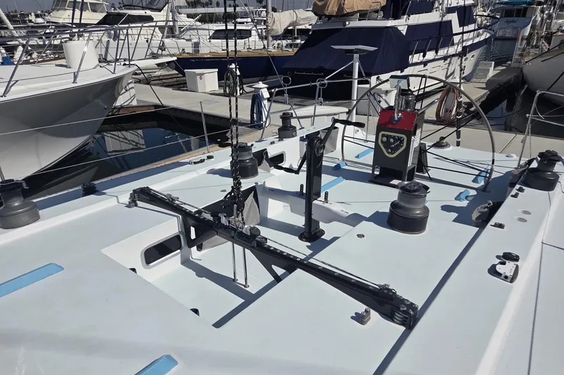 Slide: The Image of 1986 Santa Cruz 70 sailboat deck with winches and rigging in a marina. - 22