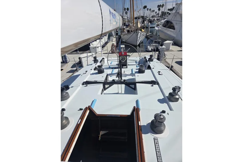 Slide: The Image of 1986 Santa Cruz 70 sailboat deck view at marina, showcasing winches and rigging. - 24