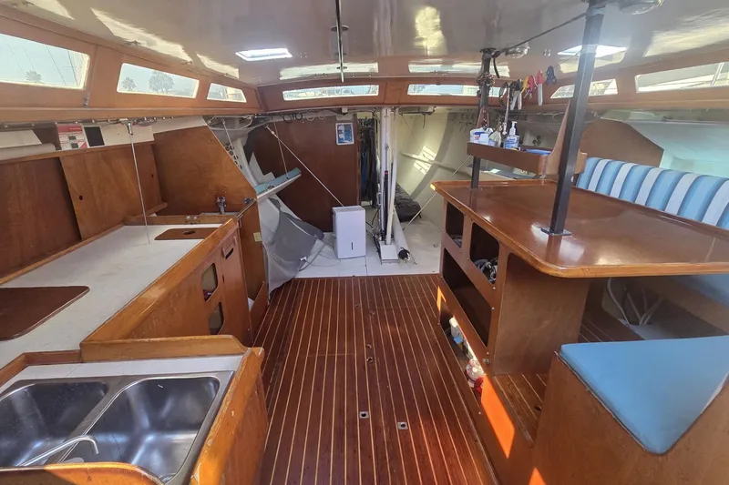 Slide: The Image of Interior of 1986 Santa Cruz 70 sailboat with wooden finishes and striped seating. - 7